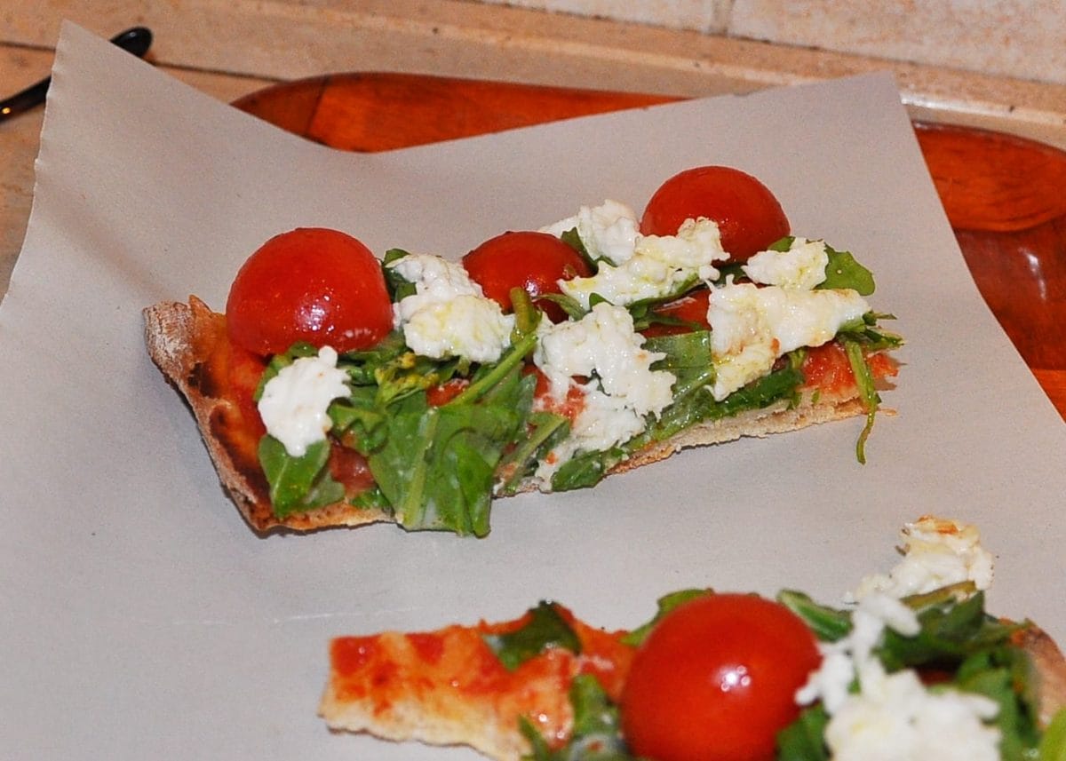 Individual slices of pizza with tomato and fresh mozzarella. 