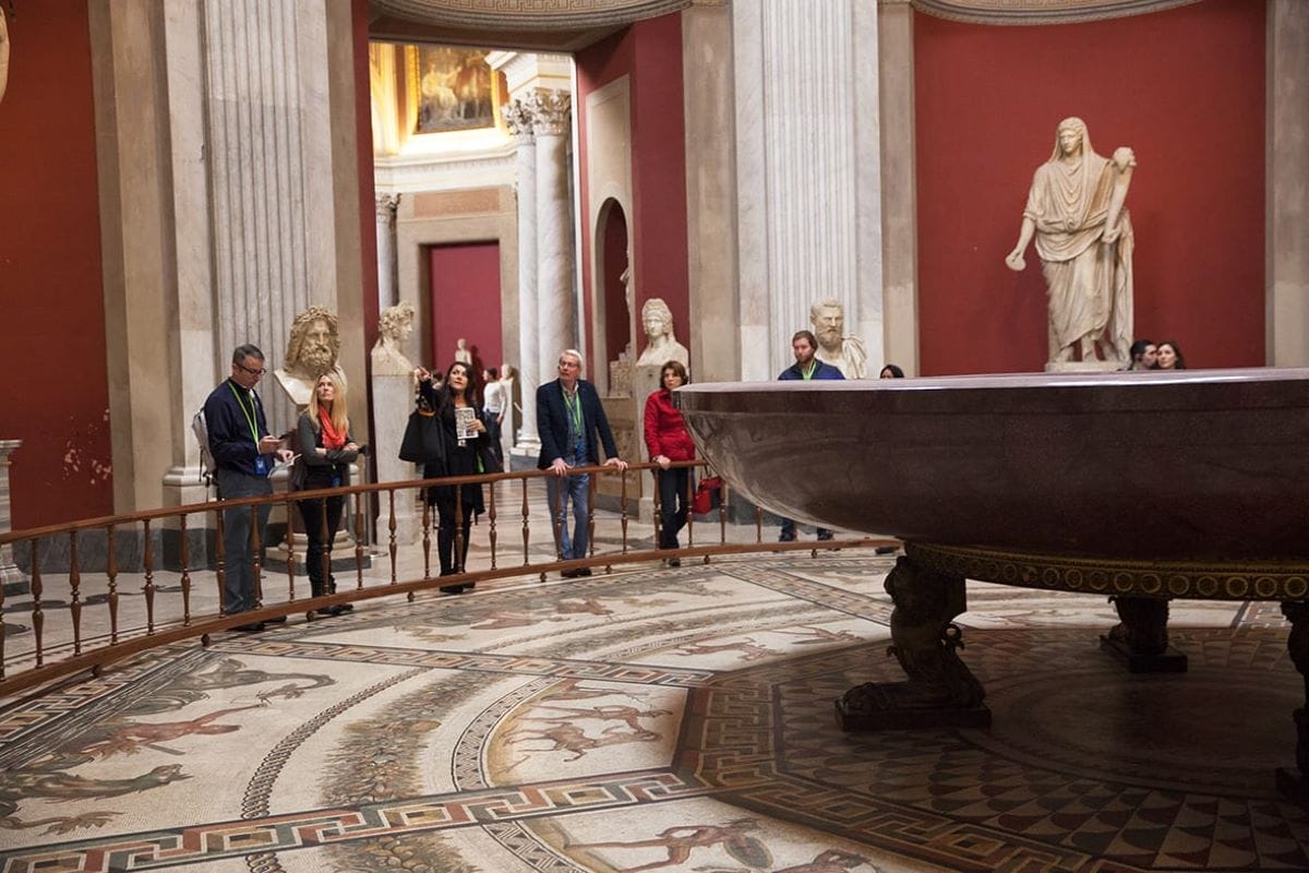 People standing near the Bath of Nero in the Vatican. 