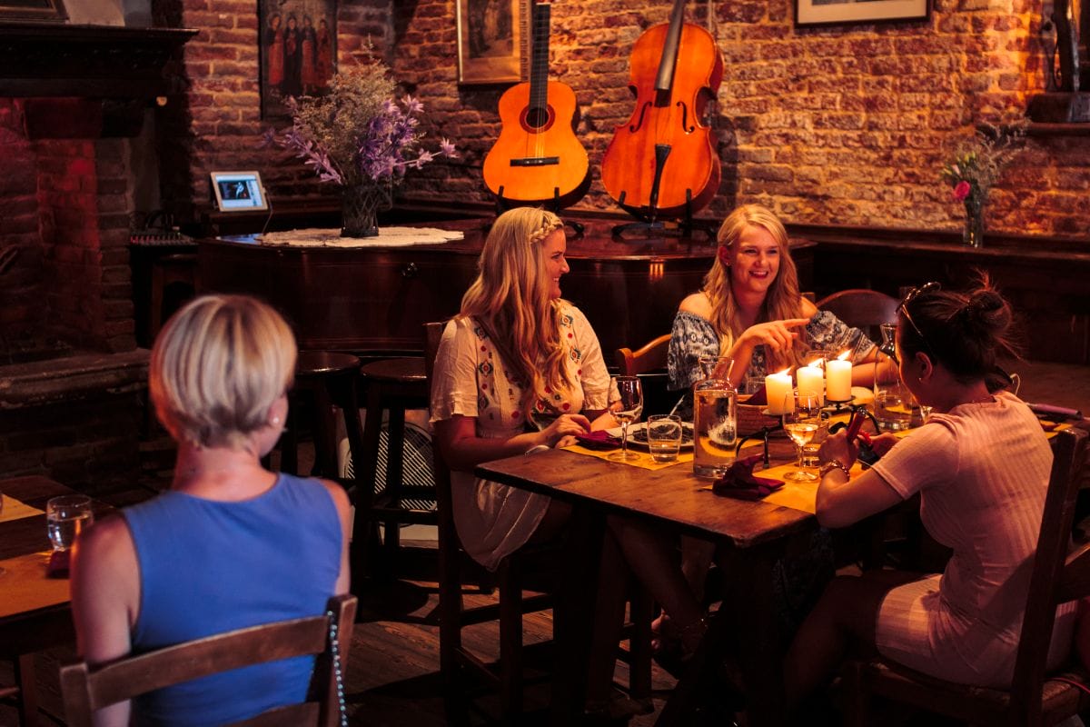 Two women sitting at a table ordering food in Venice.