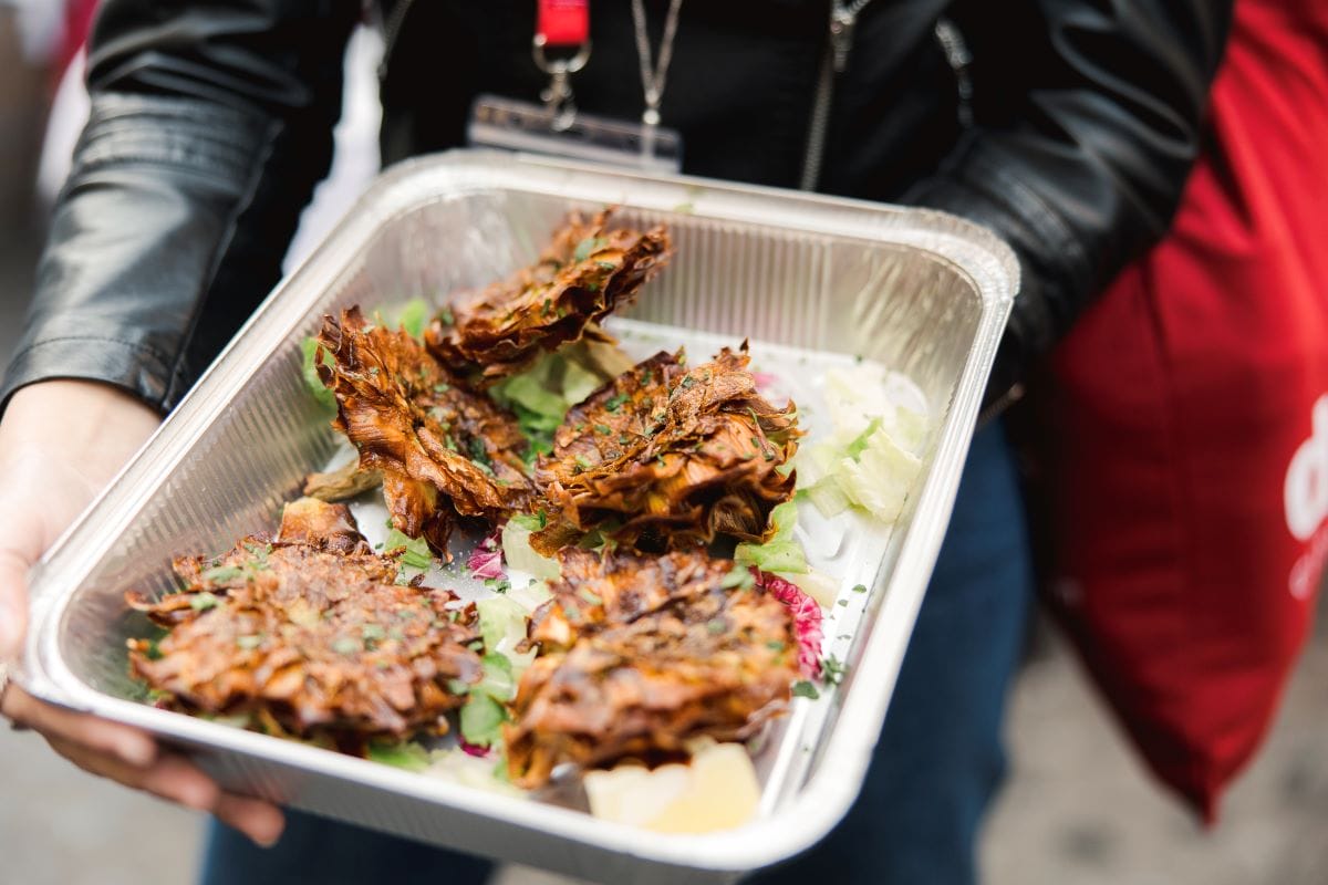 A woman holding a tray of fried artichokes in Rome. 