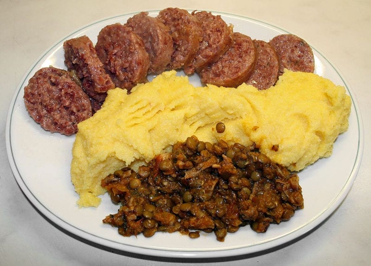 plate of sausage, yellow polenta and lentils