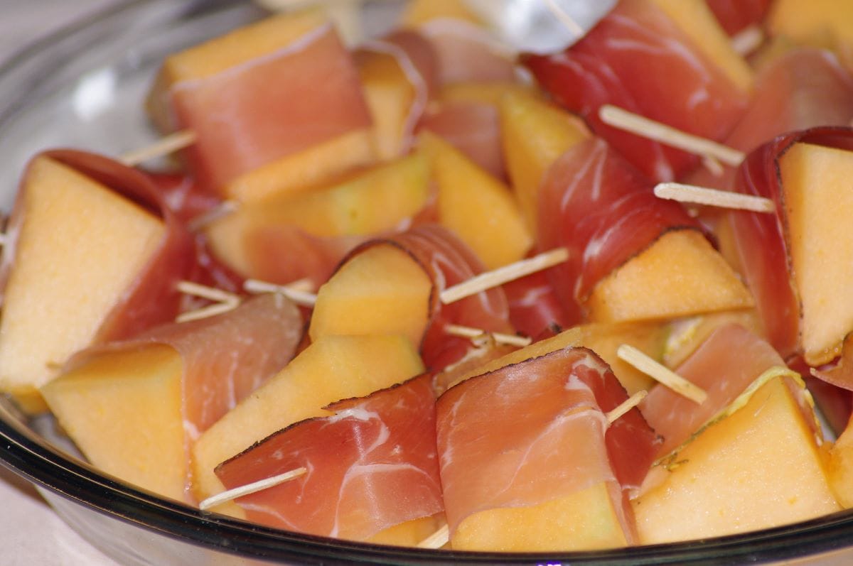 bowl of melon pieces wrapped in prosciutto