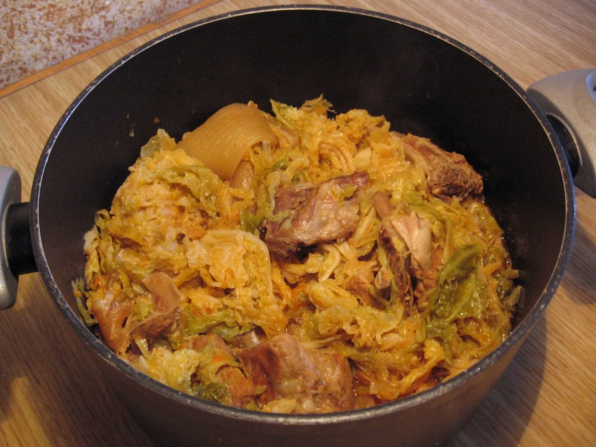 black pot of stew with cabbage and pork