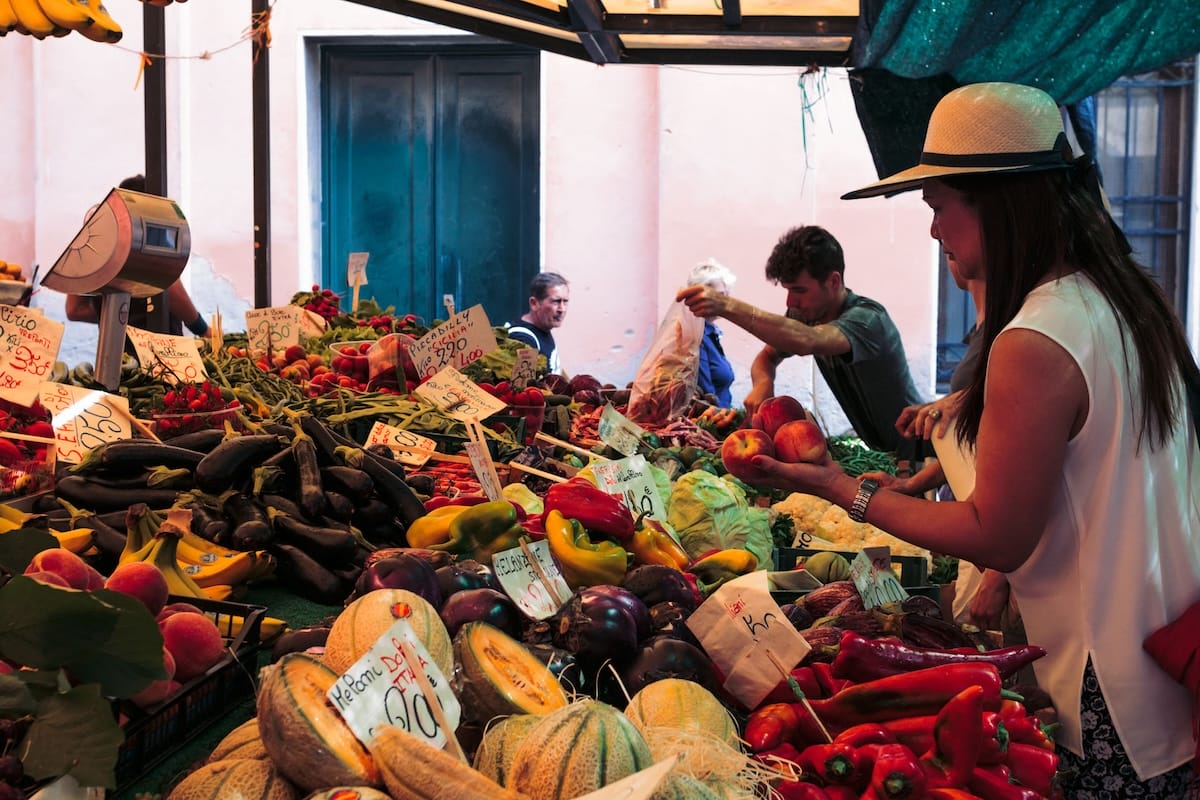 people picking out fruit in large market