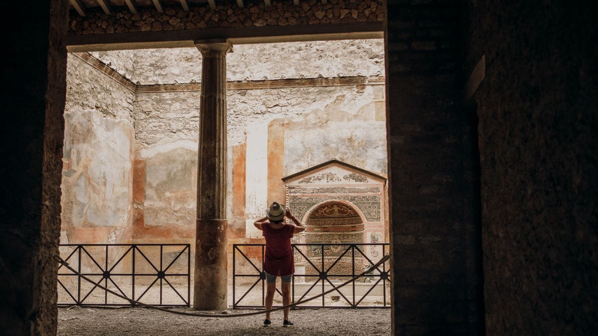 woman taking a photo inside an ancient room