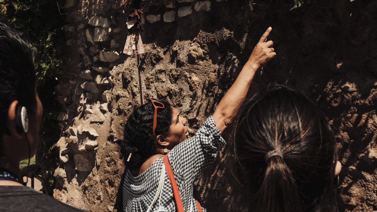 A woman pointing at Roman architecture at the Colosseum. 