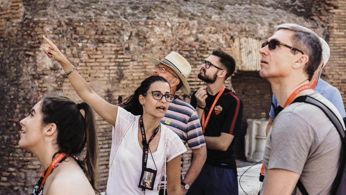 A tour guide explaining Roman architecture facts at the Colosseum. 