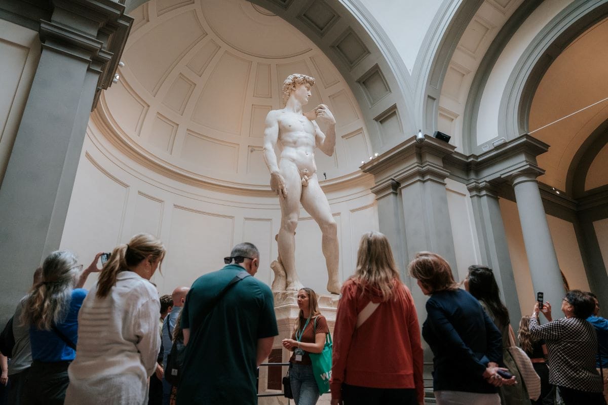 people staring at large statue of man