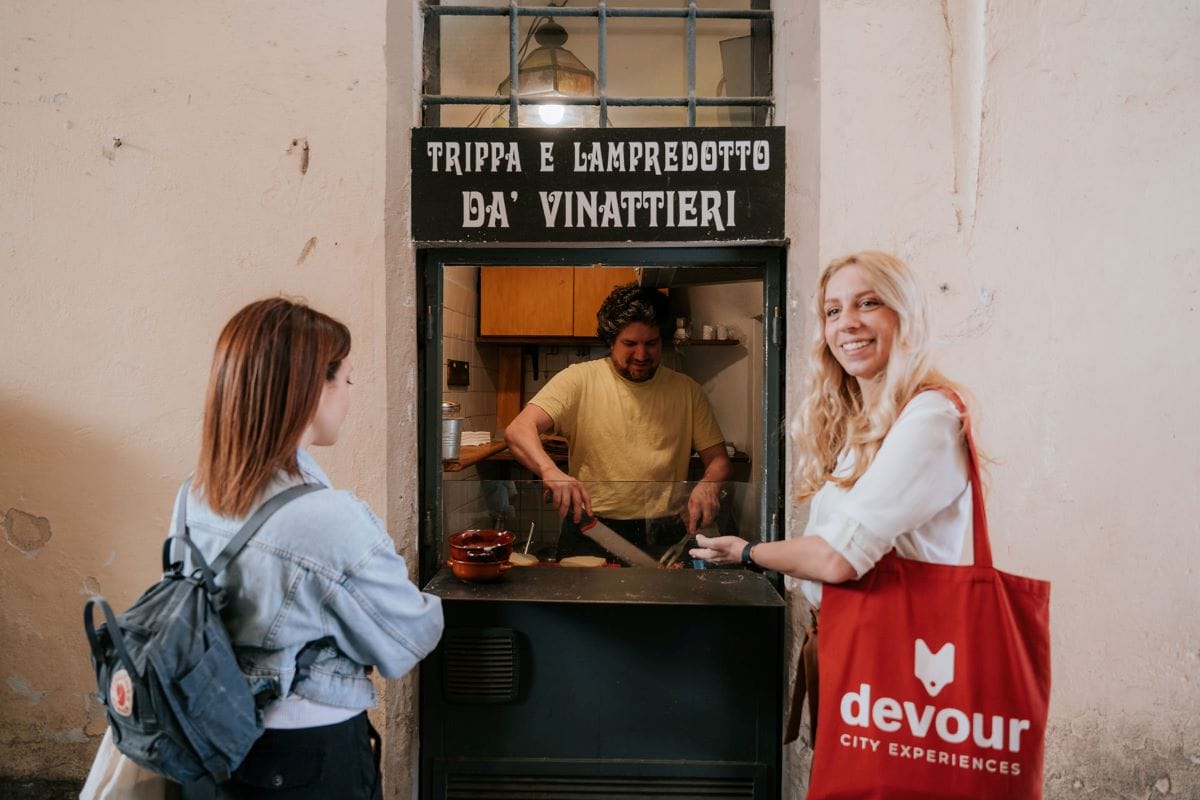 two women ordering from a small sandwich shop in italy