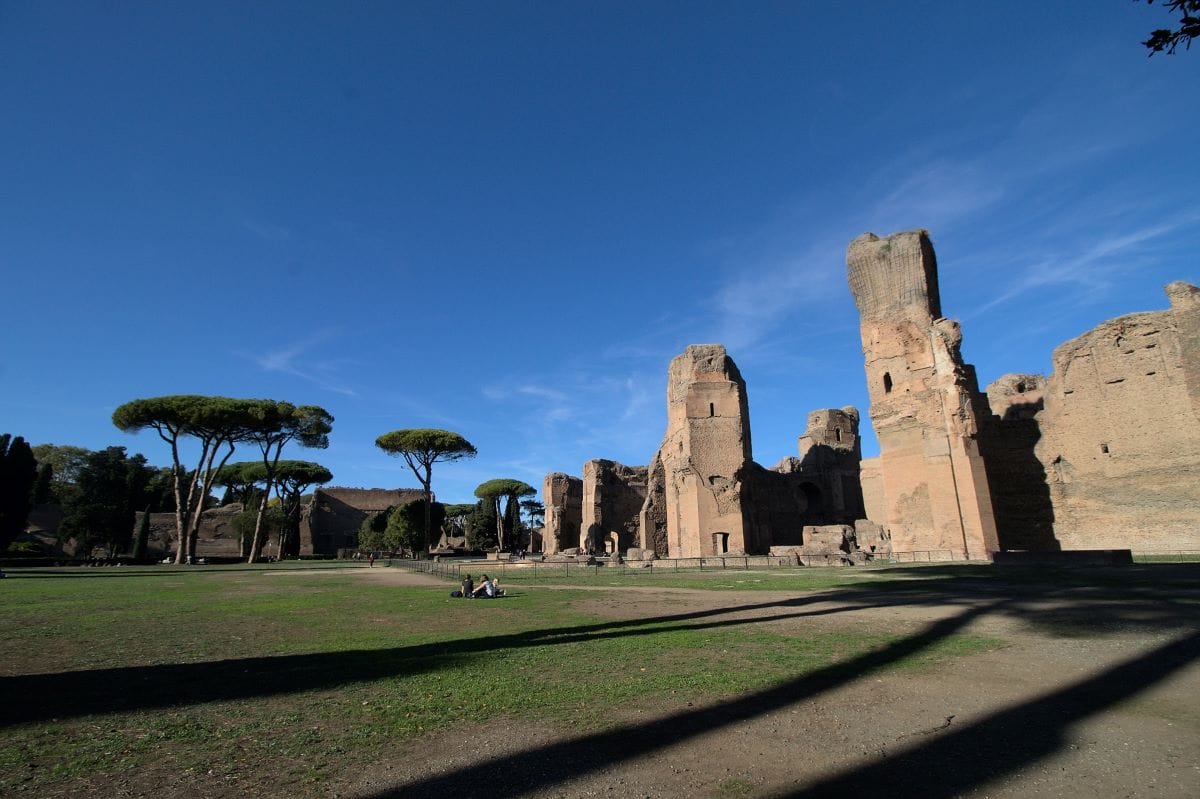 large green space with ruins on one end