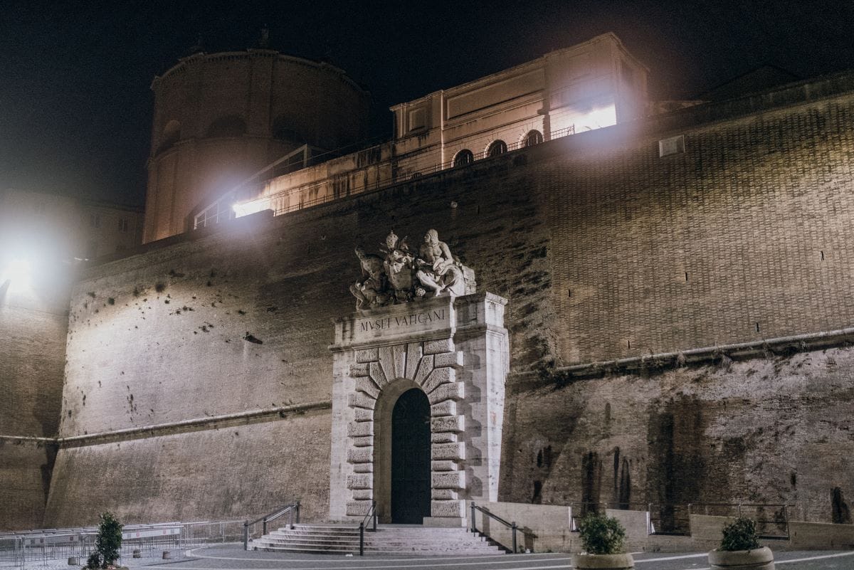 a concrete building with arched entrance at night