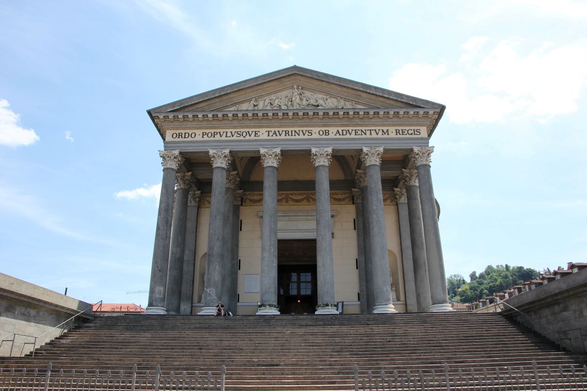 a large building with a-frame roof and columns at the entrance. 