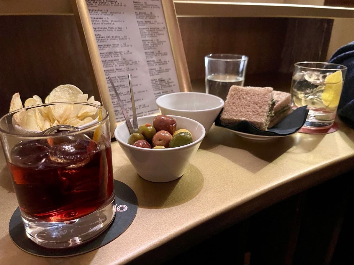 small bar with various plates of potato chips, olives, bread, and drinks