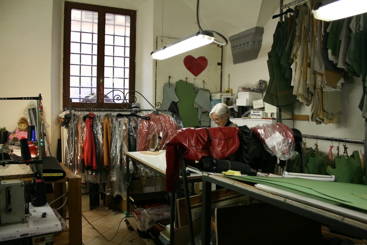 a woman working making leather in a factory in Florence