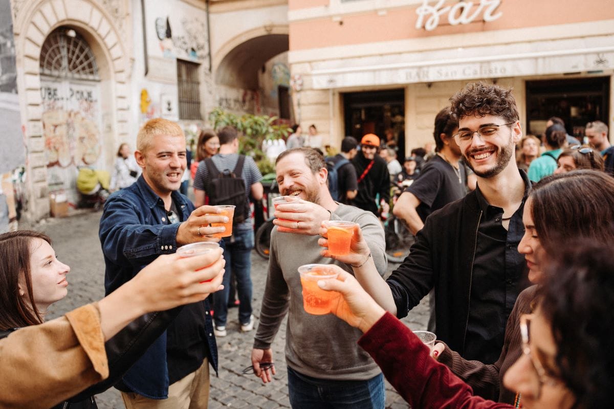 A group of people cheering glasses of aperol spritz