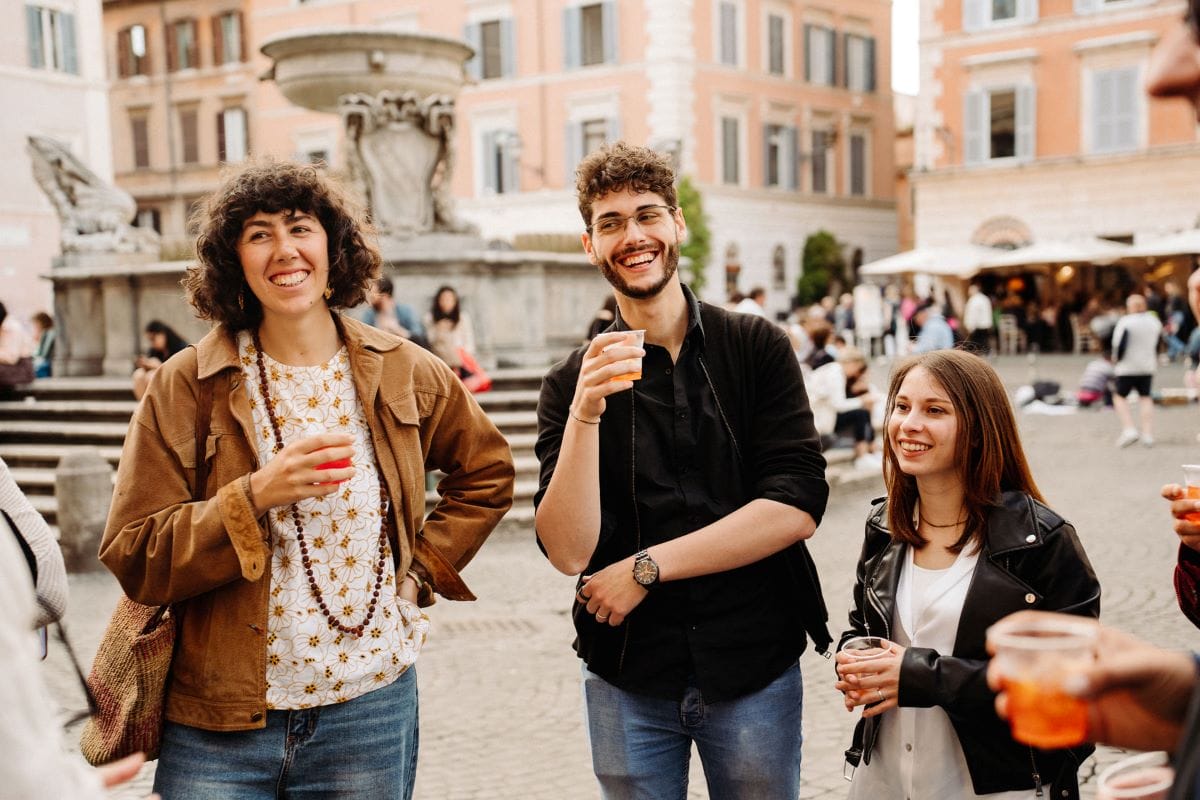 A group of people holding spritz and laughing.