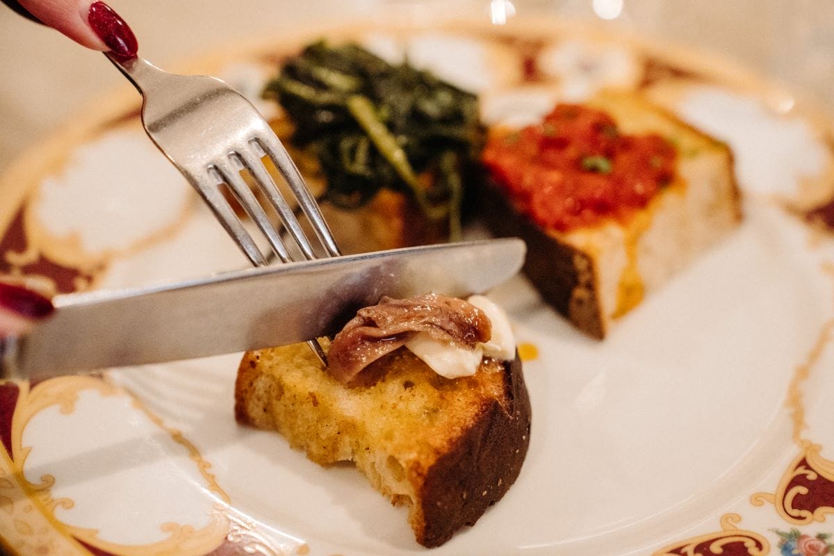 A person slicing into homemade bruschetta in Italy.