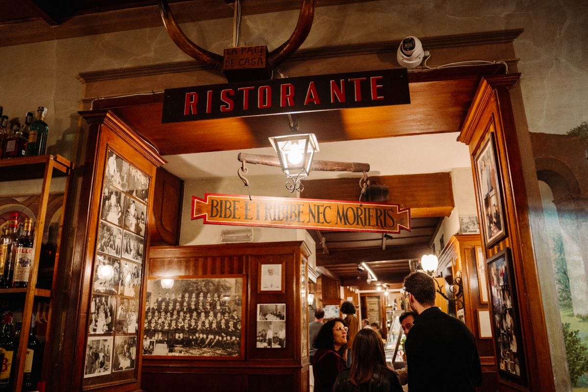 People standing in the entrance of a restaurant in Trastevere neighborhood.