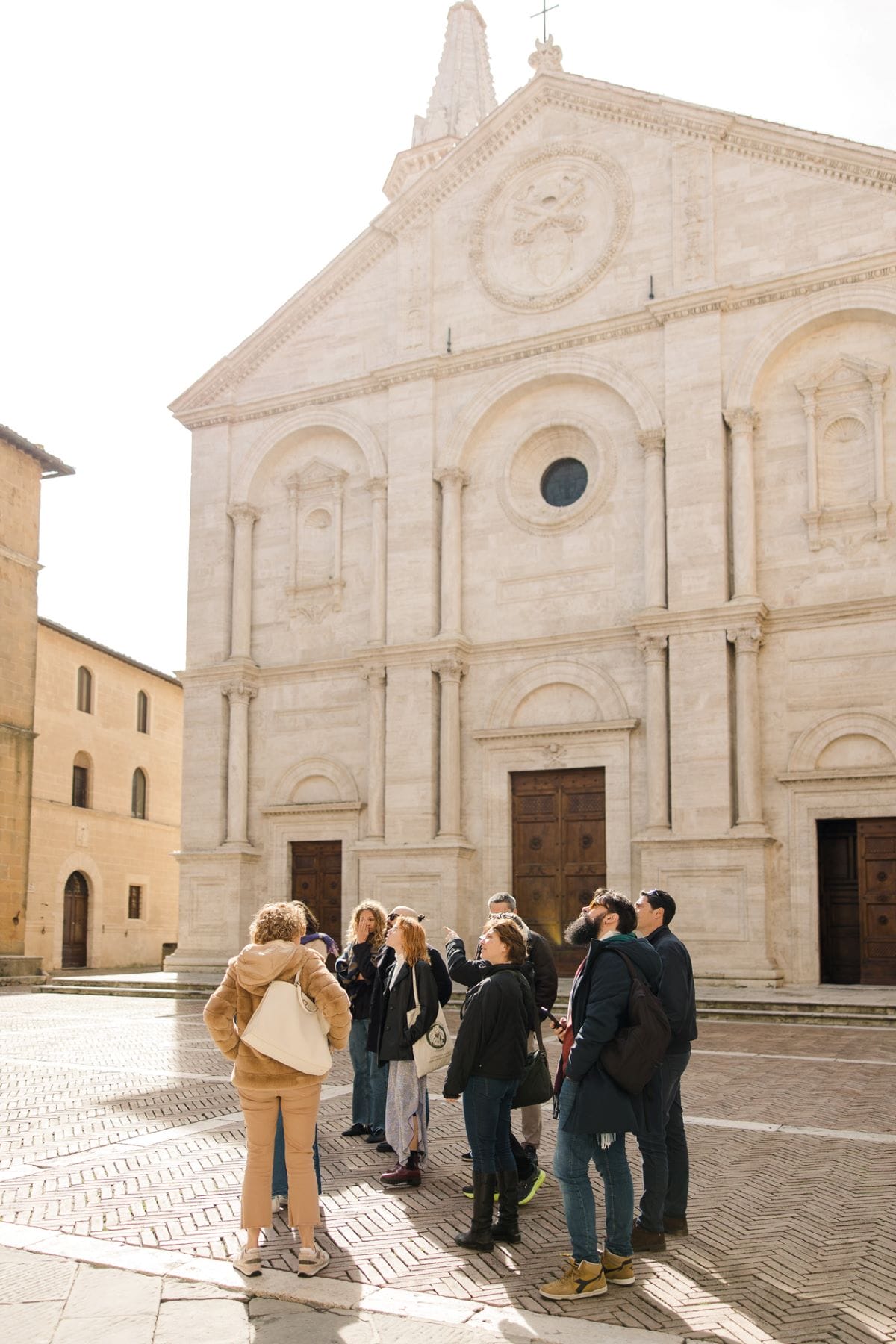 A group of people in front of the Monticchiello cathedral in Tuscany.