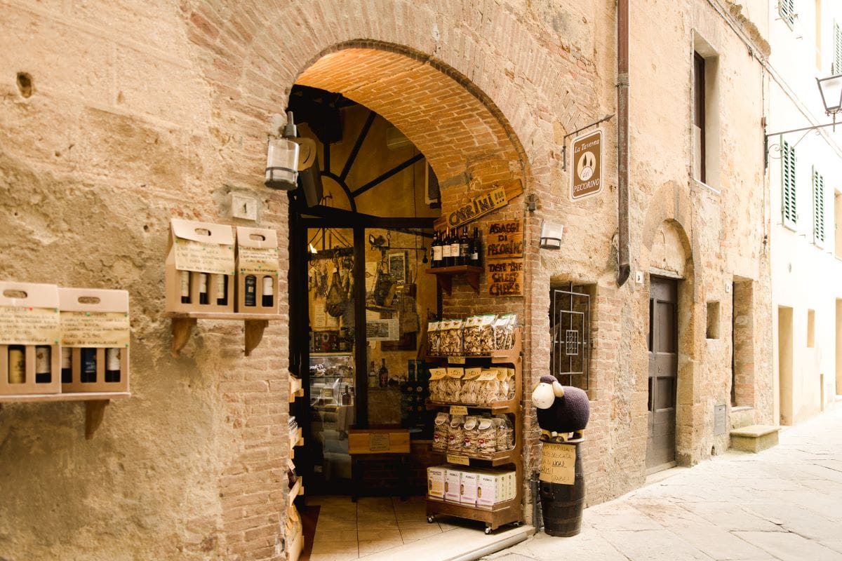 A storefront with crackers, pasta, wine, and olive oil on shelves in Tuscany.