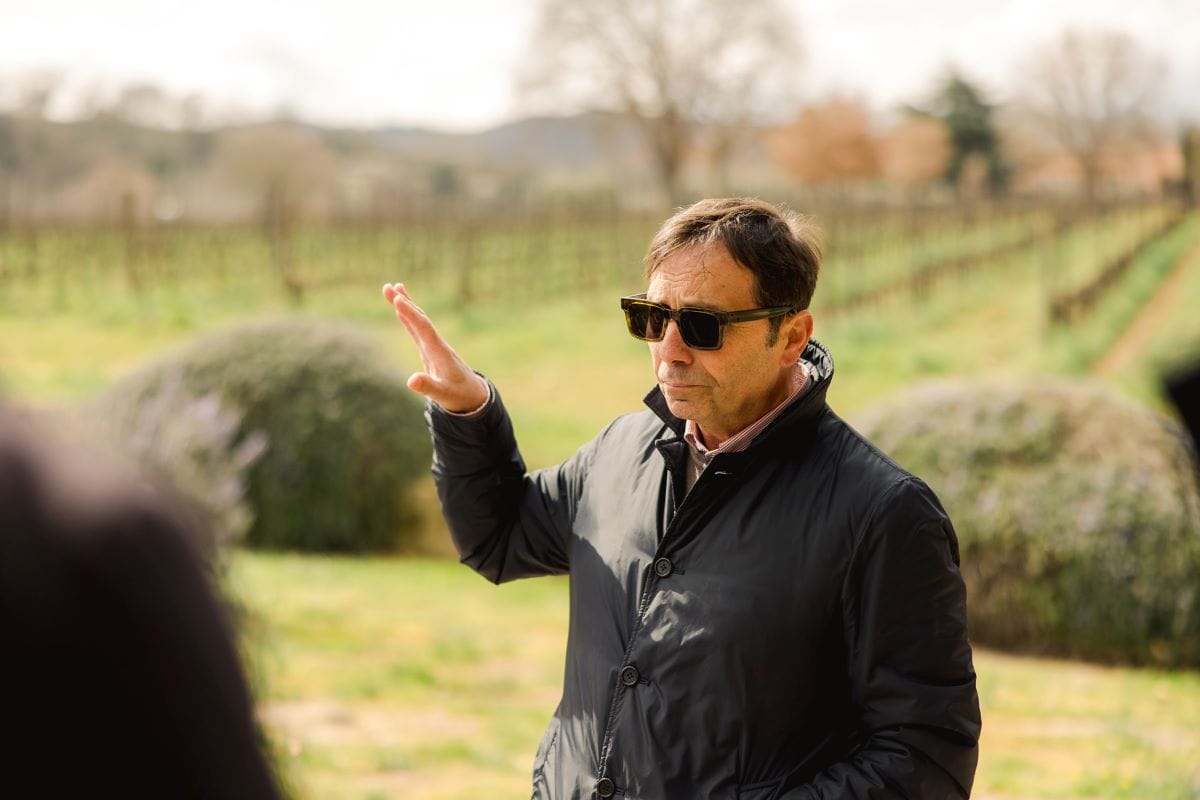 A tour guide explaining the wine making process at a vineyard in Monticchiello.