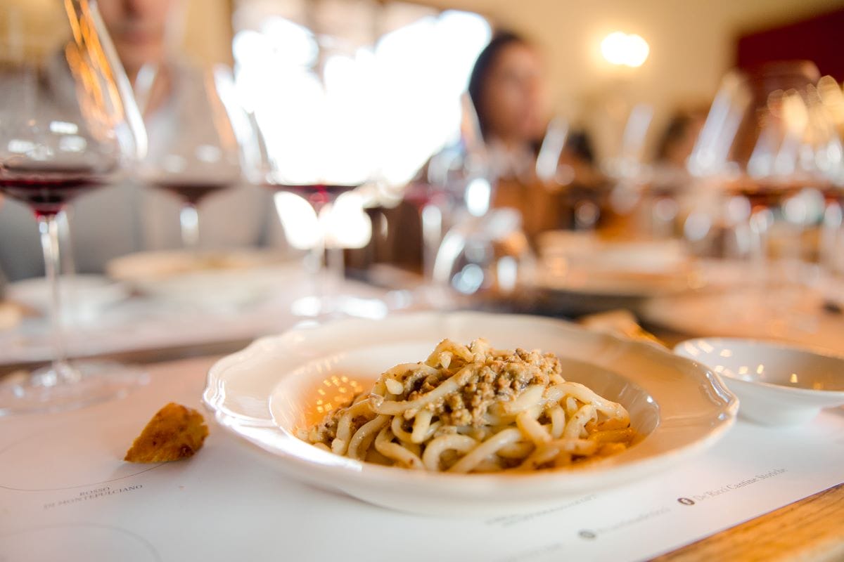 A seasonal Tuscan pasta dish on a white ceramic plate.