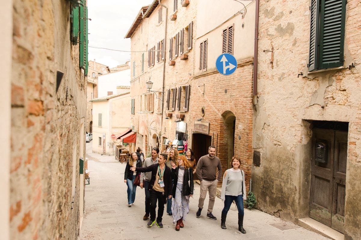 A group of people exploring Pienza's streets.