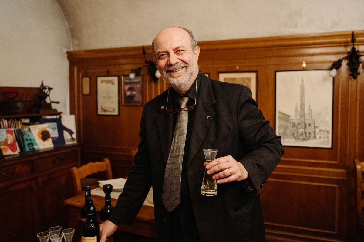 man smiling and holding a small carafe in his hand