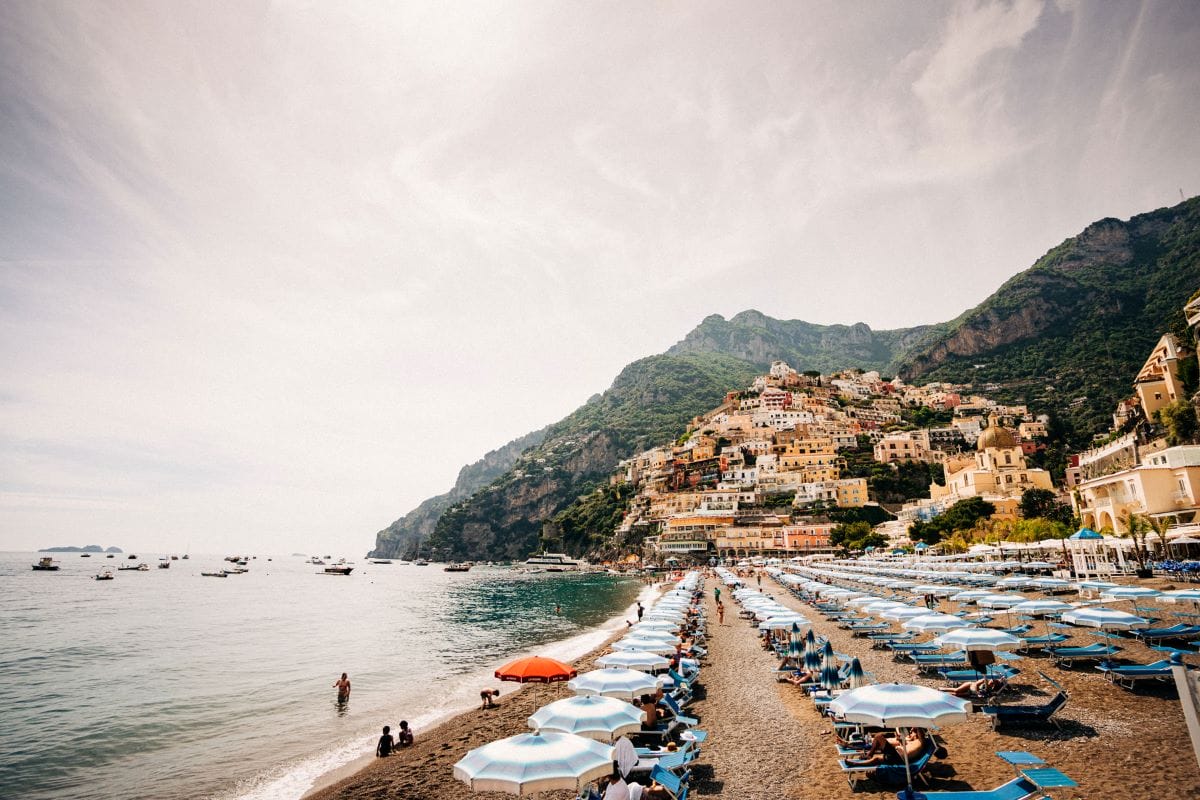 a beach area with lounge chairs and umbrellas