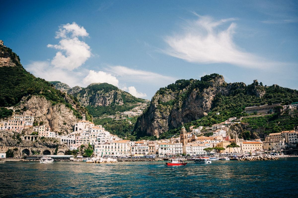 a beautiful view of colorful houses built on a cliffside overlooking the sea