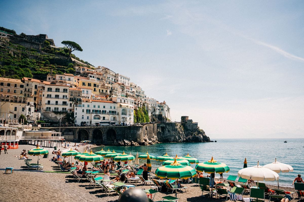 a beautiful view of a beach with colorful houses built on a cliffside