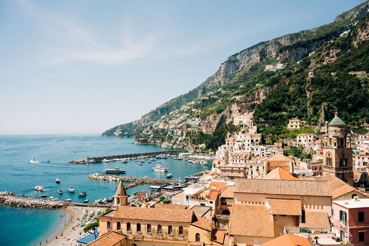 a beautiful view of colorful houses built on a cliffside overlooking the sea