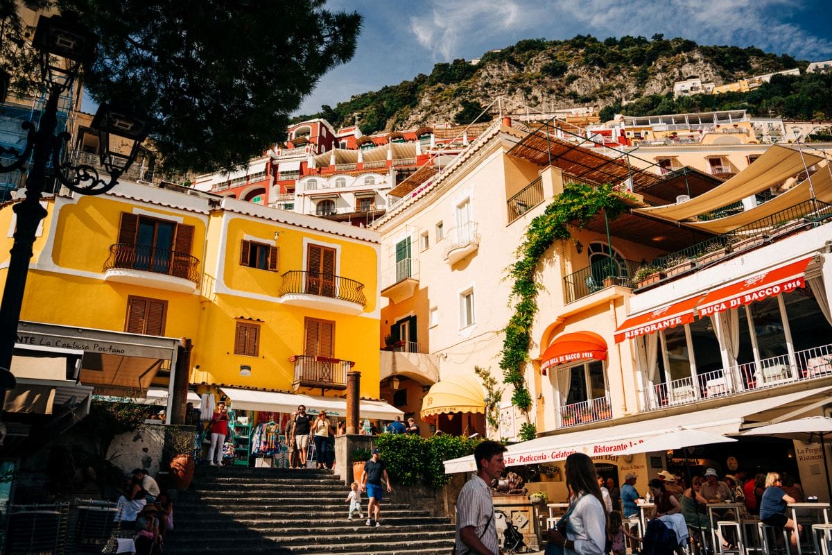 a beautiful scene people mulling about colorful buildings and a terrace