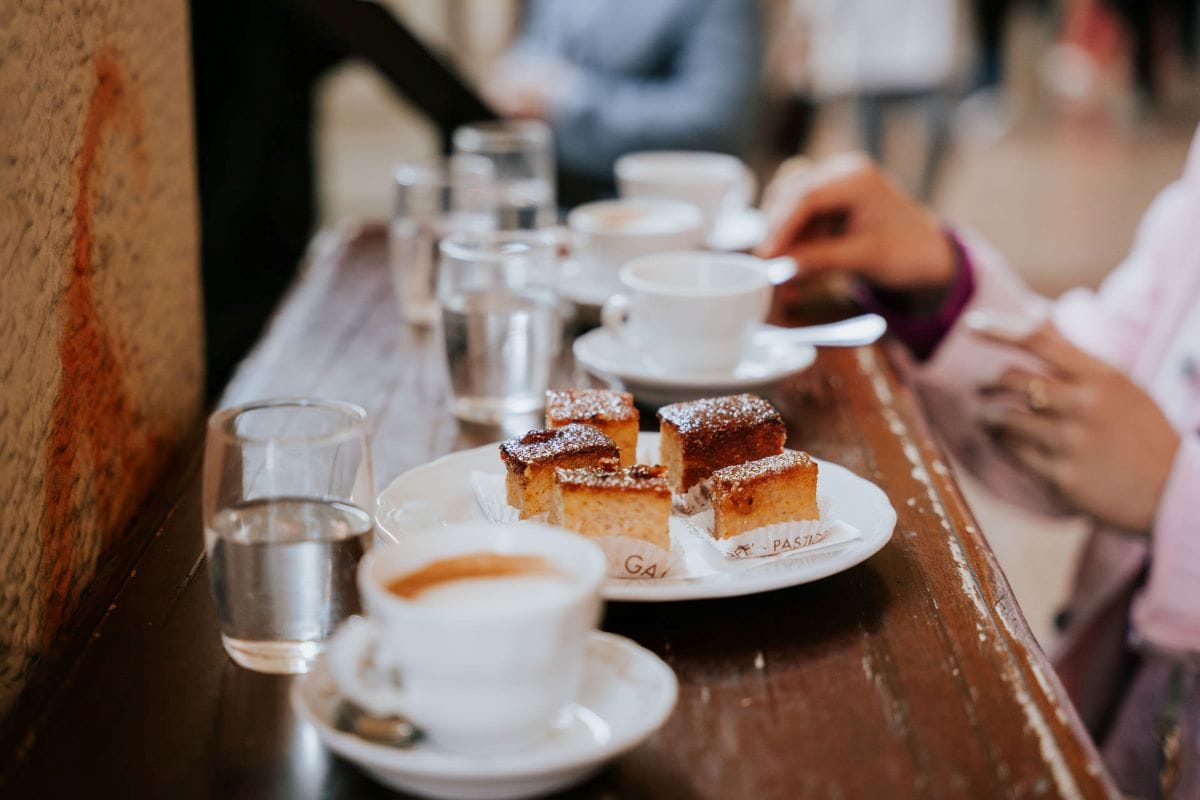 coffee cups and small pastries on a bar