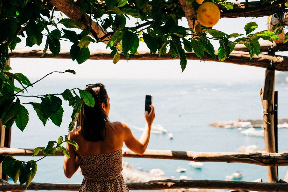 A woman taking pictures at a viewpoint in Amalfi Coast. 